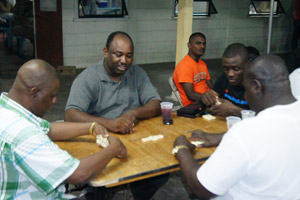 Police ranks play a game of dominos at the wake for their slain colleague on Tuesday night (Leroy Smith photo) alt