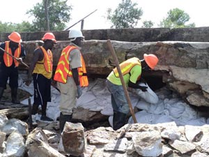 Sandcrete bags being filled into cavity by Force Account Unit team.