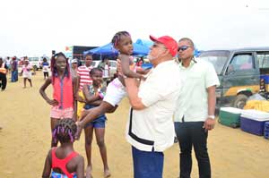 President Donald Ramotar hoists this little lass at the Number 63 Beach as her younger siblings look on