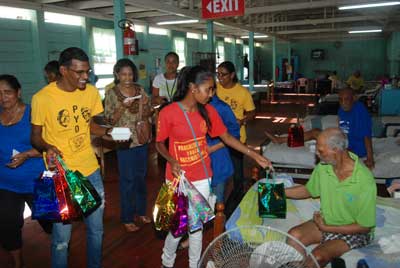 First Lady, Madame Deolatchmee Ramotar (third left) and PYO members helping spread belated Father’s Day cheer at The Palms yesterday