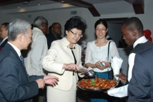 Chinese Ambassador to Guyana, Mr. Zhang Limin (left) encourages China’s Minister of Health, Madam Lin Bin to sample some of Guyana’s mouth-watering delicacies