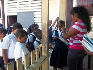 EYDG members distributing books to schoolchildren at Enterprise Primary 