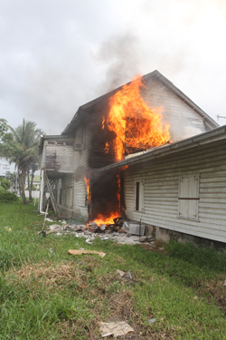 Flames ablaze, just as they begin to engulf the building on the right