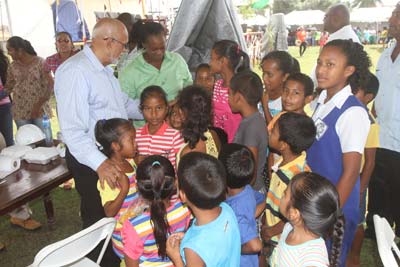 President Donald Ramotar chats with children at the Bartica Community Ground yesterday 