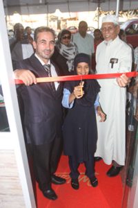 Little Sarah Amin cuts the ribbon to officially open the restaurant, as CEO Mustafa Kanakir (left) and Shaheed Mohamed (Imam) look on 