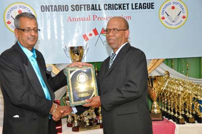 Guyana Chronicle’s Frederick Halley (right) receives his plaque from OSCL president Albert Ramcharran