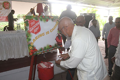President Donald Ramotar makes the first donation to the kettle.