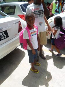 A child poses with her newly acquired back-pack