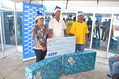Terry DeFrietas (at centre) happily poses with his $1M cheque alongside Bibi Raiwapan and Jewan Seenarine, who both won smart flatscreen television sets in the GT&T “All I Want For Christmas” promotion yesterday