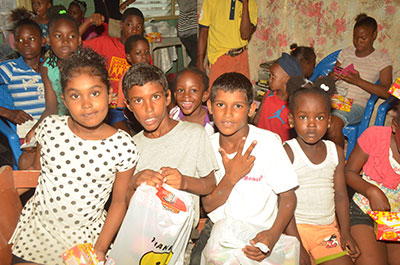 Several children pose with their toys gifted by National Hardware (Guyana) Ltd.