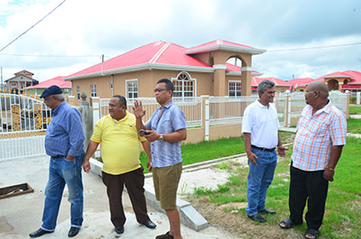 Acting Deputy Minister of Agriculture, Djoemadie Kasanmoesdiran (yellow T-shirt) viewing, with members of the Suriname Delegation, a ‘Young Professional House’ in Eccles New Scheme