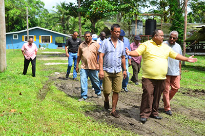 Acting Deputy Minister of Agriculture, Djoemadie Kasanmoesdiran, and delegation walking through the farms at Bounty Farm