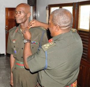 Chief-of-Staff, Brigadier Mark Phillips as he decorates newly-promoted Col. Wilbert Lee with his new badge of rank
