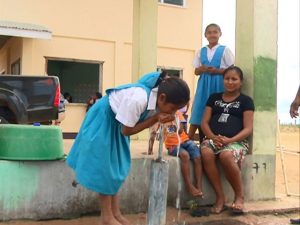 A student of the Baitoon Primary School, Region 9, drinking water from the school's standpipe