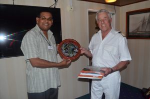GTA Director, Mr Indranauth Haralsingh handing over some items on Guyana to the Sea Adventurer’s Captain Peter Ushke