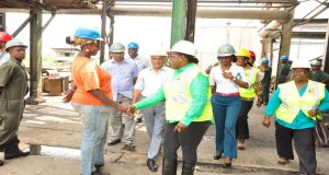Minister Broomes greets a female engineer at the Enmore Sugar Factory on Friday