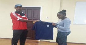 Ronecia Lewis (right) is handed a jersey by local referee instructor Abdullah Hamid.