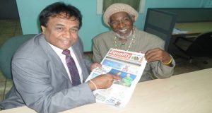 Mr. Bhaskar Sharma, publisher of the Equality newspaper, and Managing Editor Ras Leon Saul point to a photo in their publication where Sharma is seen congratulating President Granger on his accession to the presidency
