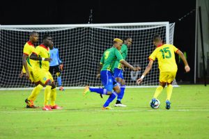 Emery Welshman (no.15) takes on Myron Samuels in the midfield against St. Vincent and the Grenadines. (Samuel Maughn photo)