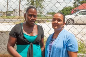 Donna Don (right), the widow of bus driver Felix Marc; and Natasha Willie, relative of the deceased Delroy Evans, who died in the smashup, stand outside the Providence Court on Friday