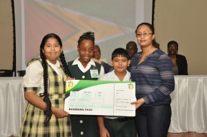 ‘FLYING HIGH’: A Representative of airline carrier Fly Jamaica with the Top 3 performers of this year’s NGSA exams -  Solomon Cherai, Shania Eastman and Celine Farinha, all of whom (along with a parent each) will receive airline tickets to any of Fly Jamaica’s destinations 