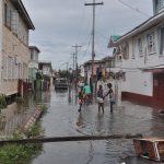 Residents block streets in Albouystown to help keep the water out of their homes