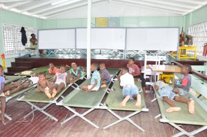 Several children rest on the beds provided by the CDC yesterday at one of the shelters.