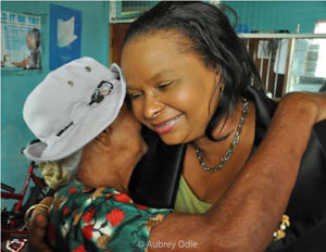 Minister of Social Protection, Volda Lawrence receives a hug from a pensioner