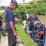 Members get on a boat to engage in garbage clean-up and other works  