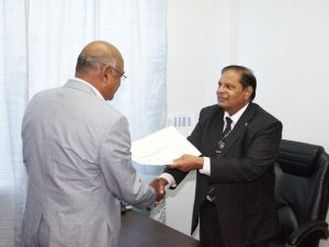 Prime Minister Moses Nagamootoo receives the presidential instrument from  Chancellor of the Judiciary (ag) Mr Carl Singh after he had taken the oath as President, yesterday