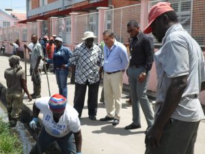 CEO of the GPHC, Mr. Michael Khan and others observe the work being done by the cleansing workforce