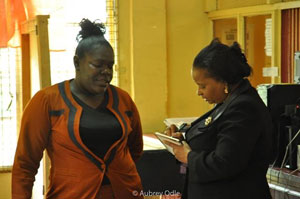 Minister of Social Protection, Volda Lawrence takes note of a Post Office employee's concerns