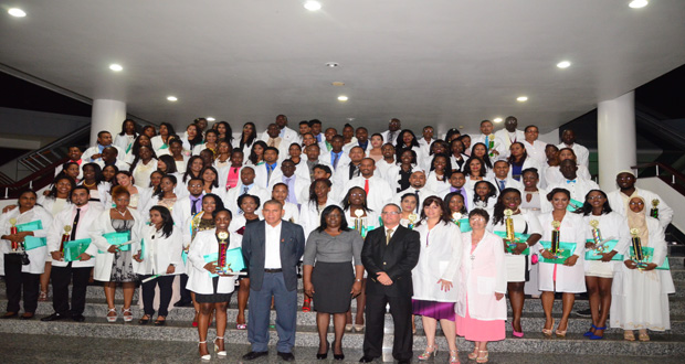 The new medical doctors showcasing their certificates and trophies in the presence of Minister of Public Health, Dr. George Norton [front centre); Minister within the Ministry of Public Health, Dr. Karen Cummings; and Cuban Ambassador to Guyana, Julio Marchante.