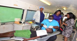 Digicel Communications Manager Vidya Brijlall-Sanichara (right) looking on yesterday while dental staffers tended to a schoolboy