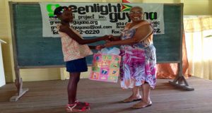 Community Advocate Mrs. Bridgette George presenting an award to the school’s other top pupil, Kaydonna Scotland