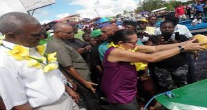 First Lady Sandra Granger pours contents of a water coconut on the bow of the new boat 