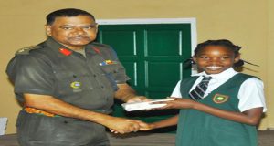 Top student at this year's Bursary Awards Amba Skeete receives her special prize from Deputy Chief of Staff, Colonel Khemraj Persaud 