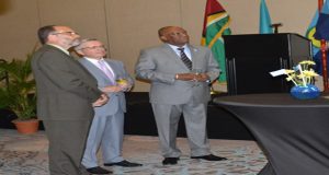 From left, Minister of State Joseph Harmon, Ambassador Konstantin Zhigalov and Caricom Secretary General Irwin LaRocque pay attention to a presentation on the Republic of Kazakhstan 