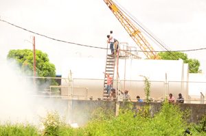  Dangerously close! Curious onlookers looked on yesterday as Fire fighters battled this fire which erupted in close proximity to the Sol Guyana compound, where in excess of 10,000 barrels of fuel are stored.