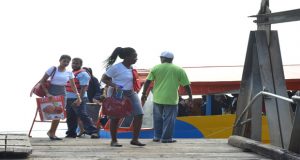 Two teachers from the Cyril Potter College of Education disembarking one of the boats at the New Amsterdam Stelling 