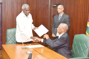 Newly appointed GECOM Commissioner, Robeson Benn collects his letter of instrument of office from President David Granger