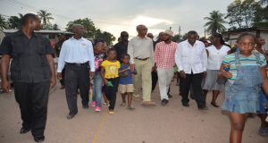President Granger is accompanied by youths during his walkabout in One Mile Wismar