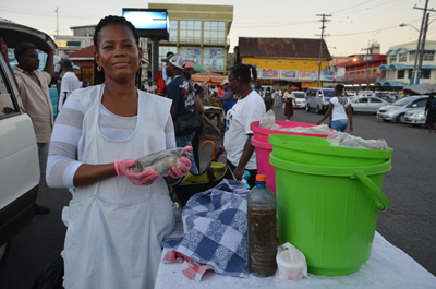 Claville poses with her freshly scented puddings at the Stabroek Market