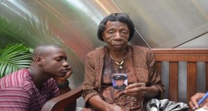 Elizabeth Lovell displays a photo of her slain grandson, Randolph Holder. To her left is Kelon Noel. Ms Lovell brought up the two boys after their mother had died of cancer.