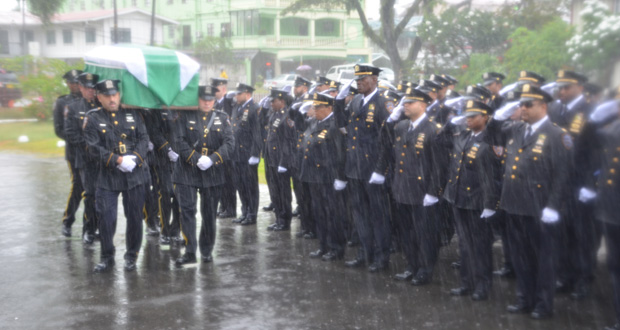 NYPD officers braved the rain in a final salute as the body of officer Randolph Holder arrived at the Brickdam Cathedral on Saturday [Delano Williams photo)