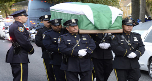Police officer carry the casket of Holder during his wake on Tuesday