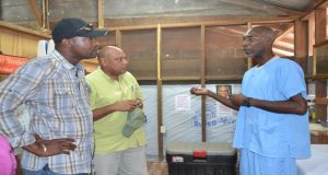 Minister David Patterson (left) and Minister Raphael Trotman listen as a staff member explains how the health centre of the company functions 