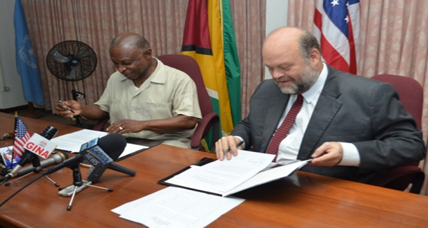 Minister of Foreign Affairs Carl Greenidge and U.S. Ambassador Perry Holloway, affixing their signatures to the Caribbean Basin Security Initiative’s [CBSI’s) “Letter of Amendment 3.2,” in the Main Conference Room of the Ministry of Foreign Affairs (GINA photo)