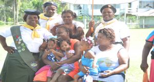 Residents of Baracara sit under an umbrella as President David Granger addresses the community (Delano Williams Photo)