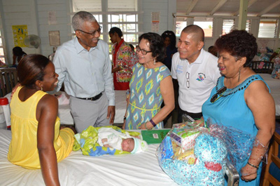 President David Granger, First Lady Sandra Granger, Health Minister Dr. George Norton and Minister of Social Cohesion, Ms. Amna Ally, having a laugh with the mother of one of the babies born on Christmas Day, Ms. Renita Patterson of Buxton.  This is Renita's fourth child, and her first girl. (Ministry of the Presidency photo) 